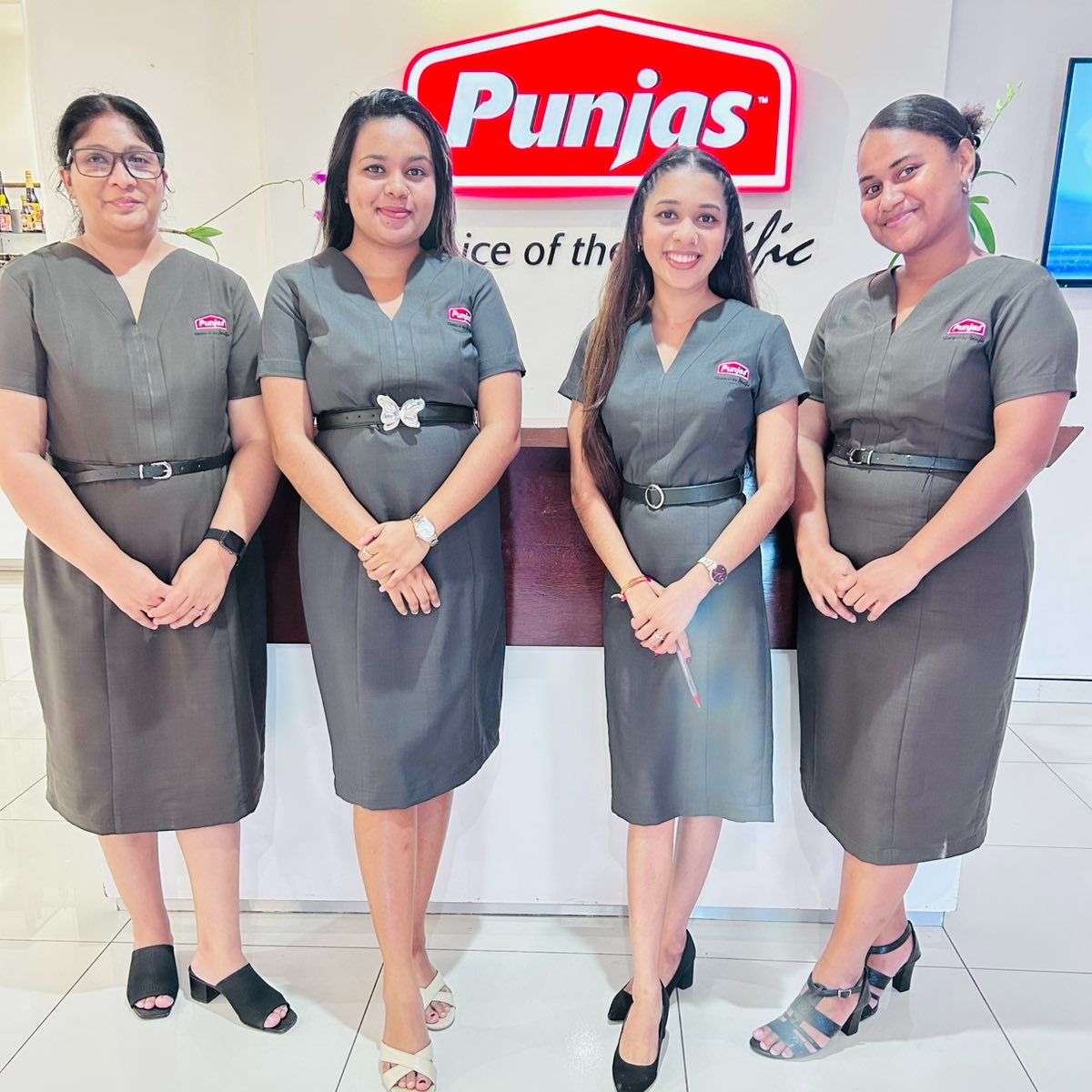 Punjas reception team in tailored grey belted dresses